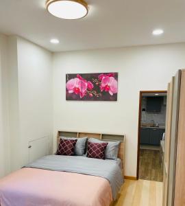 a bedroom with a bed with pink flowers on the wall at Baannira บ้านนิรา in Ban Sam Kong