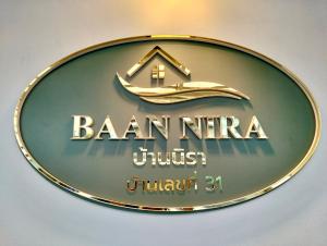 a sign for a hotel with a house on it at Baannira บ้านนิรา in Ban Sam Kong