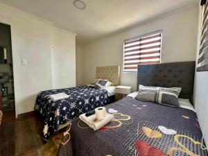 a bedroom with two beds and a window at Sunset Iquique in Iquique