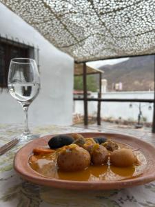 a plate of food on a table with a glass of wine at Sentido Huacalera - Guest House in Tilcara