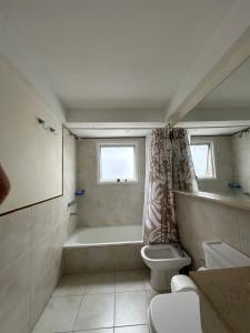 a bathroom with a tub and a toilet and a sink at Alberti Apartament in San Isidro