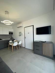 eine Küche und ein Esszimmer mit einem Tisch und einem TV in der Unterkunft Casa Vacanza Da Angela & Corrado in Pozzallo