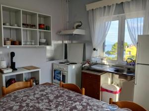 a kitchen with a stove and a sink and a table at Helen's Seaside Apartment in Nafpaktos