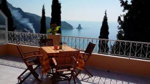 アギオス・ゴルディオスにあるStella's Apartmentsのテーブルと椅子、海の景色を望むバルコニー
