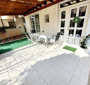 a patio with a table and chairs and a pool at Bonjour Vendégház in Nyíregyháza