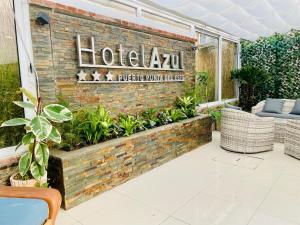 a hotel akhtar sign on a brick wall with plants at Hotel Azul by MH in Punta del Este