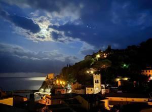 a view of a city at night with a clock tower at Good Vibes Apartment in Monterosso al Mare +10 photos