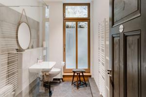 Un baño blanco con lavabo y espejo. en Chalet HAUS WANDERLUST, en Thale
