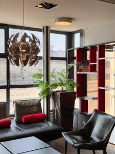 a living room with a couch and a potted plant at Kyriad Hotel Dijon Gare in Dijon