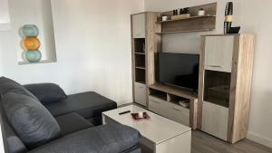 a living room with a couch and a tv at Apartamento nuevo casco antiguo in Ponferrada
