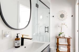 baño con bañera blanca y espejo grande en Sleek Luxury Studio with Patio LAX & Beach Access, en Los Ángeles