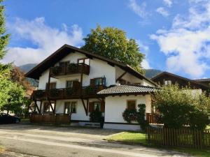 a large white house with balconies on a street at Haus-Schneider-Sepp in Ettal
