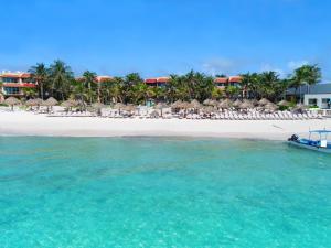 a boat in the water next to a beach at Grand Oasis Tulum Riviera - All Inclusive in Akumal