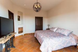 a bedroom with a bed and a flat screen tv at Villa Jade in San Miguel de Allende