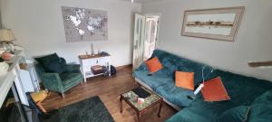 a living room with a green couch and two chairs at 17 DB property in Wexford