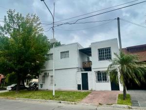 a white house with a palm tree in front of it at Merlo INK in Merlo