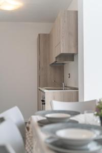 a kitchen with a table with plates on it at Residence La Corte di San Rocco in Cremeno
