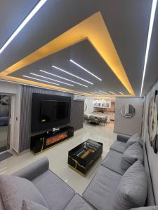 a living room with couches and a flat screen tv at Apartamento de Lujo in La Estrella