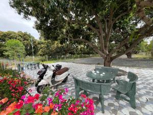 un scooter garé à côté d'une table et de fleurs dans l'établissement Casa Mango 1, à Cam Lâm 9 autres photos