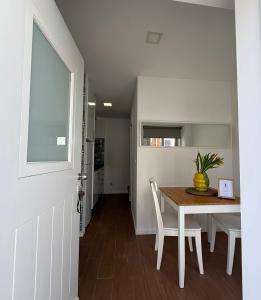 a dining room with a table with a vase on it at Casa Aurora in Trafaria +6 photos