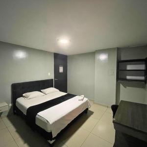 Postel nebo postele na pokoji v ubytování Hotel Escorial Ibagué