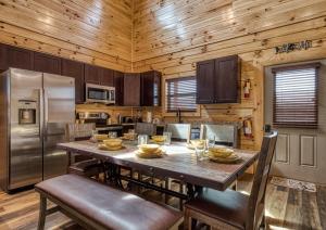 a kitchen with a table with chairs and a refrigerator at Blue Bear Splash in Pigeon Forge