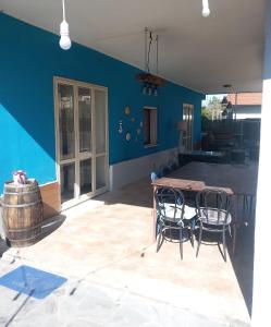 a room with a table and chairs and a blue wall at L'isola del relax in Vaccarizzo - Delfino