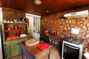 a kitchen with a stove and a stone wall at Casa de João in Ouro Preto