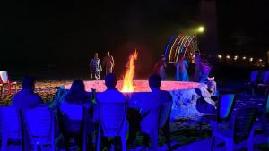 a group of people sitting in chairs around a large fire at Blackberry Wilderness Camp - Olive Element Pvt Ltd in Pasra
