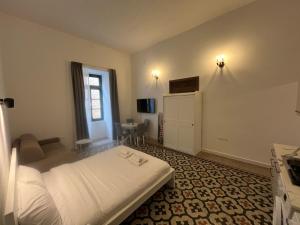 a hotel room with a bed and a couch at The Old Mint Residence 4 in Valletta