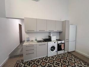 a kitchen with white cabinets and a washer and dryer at The Old Mint Residence 4 in Valletta