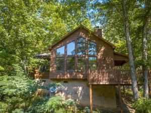 a tree house with a deck in the woods at Reflections in Sevierville