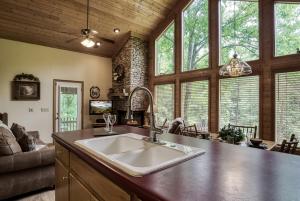 a kitchen with a large sink in a room with windows at Reflections in Sevierville +23 photos