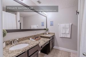 a bathroom with two sinks and a large mirror at 3BD Townhouse , Themed , 10 min to Disney , Gated in Kissimmee