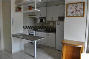 a kitchen with white cabinets and a table in it at Thermas das Caldas, Aproveite Tudo Aqui em Caldas Novas - GO in Caldas Novas