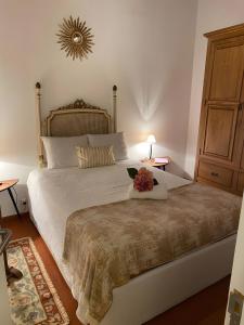 a bedroom with a large bed with a flower on it at Casinha Amarela in Cabeção