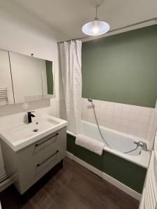 a bathroom with a white sink and a bath tub at Le National 2 Appartement centre ville avec Parking privé in Tourcoing +6 photos