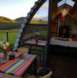 GachancipáにあるGlamping La Guadalupanaのガゼボ(テーブル、テーブル、椅子2脚付)