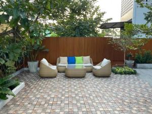 a patio with a couch and chairs on a brick patio at Jenista Pool Villa in Ban Po Mo