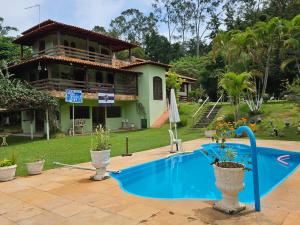 a swimming pool in front of a house at Sítio Bem Querer in Lagoa Santa