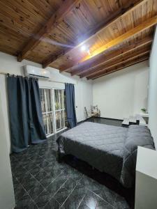 ein Schlafzimmer mit großem Bett und Holzdecke in der Unterkunft Departamento centro Maipú Mza, sobre ruta del vino, equipado para 4 personas in Maipú