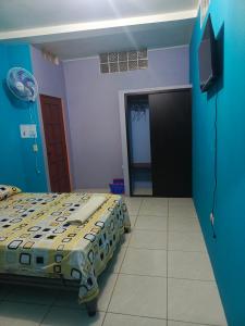 een slaapkamer met een bed en een flatscreen-tv bij Lobito in Puerto Baquerizo Moreno