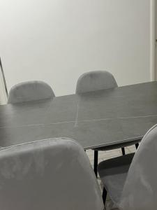 Una mesa de conferencias con cuatro sillas alrededor. en Vlore , Lungomare, en Vlorë