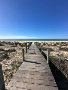 un paseo marítimo de madera que conduce a la playa en Casa Tété, en Faro