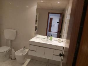 a bathroom with a sink and a toilet and a mirror at Casa Tété in Faro +28 photos
