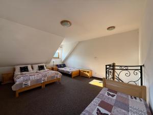 een zolderkamer met 2 bedden en een nachtkastje bij Dom Madeyski in Szczawnica