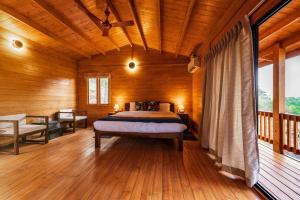 Un dormitorio con una cama en una cabaña de madera. en Vaga Rowood by WanderEase, en Vagamon