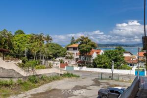 een auto geparkeerd op een parkeerplaats naast een straat bij Apto Vista Mar 240m da Praia em Jurerê IDO207 in Florianópolis