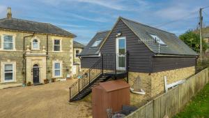a home with a black house with a staircase at Hunter Heights Loft (Countryside Views) in Wroxall