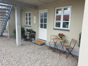 a group of chairs and a table in front of a house at Lejlighed B med dejlig privat gårdhave på Thurø Kæledyr er IKKE gratis og skal tilføjes in Svendborg